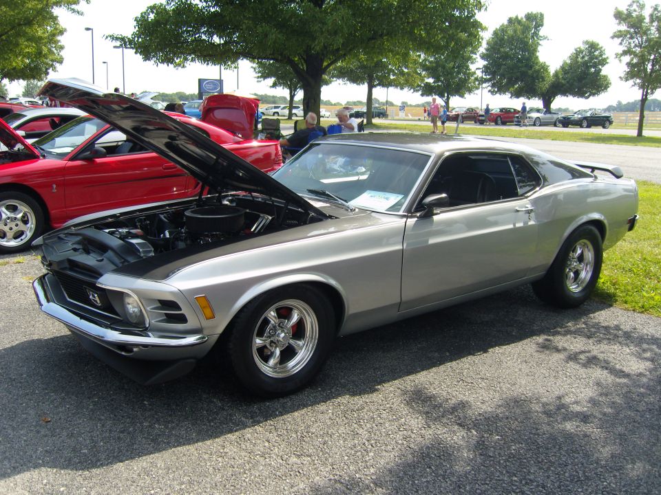 Silver 1970 Ford Mustang coupe with hood open, showing engine and black stripe on hood