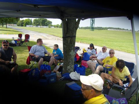 2007 Ford Mustang - Attendees relax in chairs under a shaded canopy during an outdoor gathering.