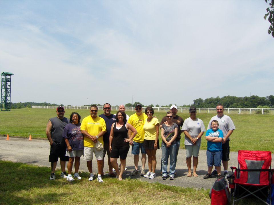 Group of people standing in a grassy field with a tower in the background