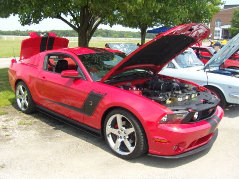 2007 Ford Mustang - A red Ford Mustang with black racing stripes is displayed with its hood and trunk open.