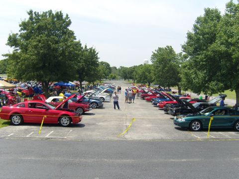 2007 Ford Mustang - A line of Ford Mustangs are displayed at a car show, with a red Mustang prominently featured in the foreground.