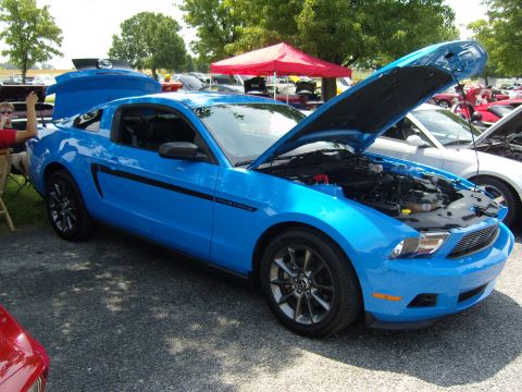 2007 Ford Mustang - Blue Ford Mustang with hood and trunk open at an outdoor car show.