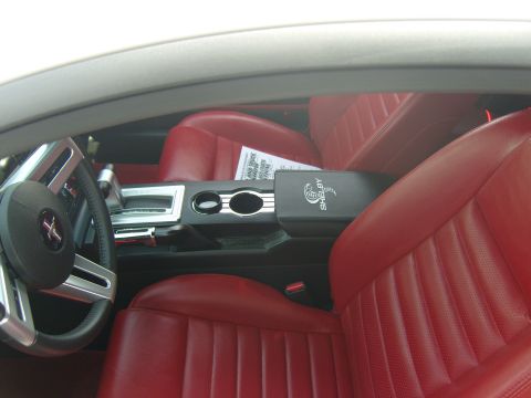 2007 Ford Mustang - The interior features red leather seats and a center console with a Shelby Cobra emblem.