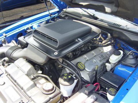 2007 Ford Mustang - The engine bay of a 2007 Ford Mustang features a V8 32 valve engine and a prominent black hood scoop.