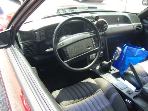 2007 Ford Mustang - The interior of a car shows a dashboard with gauges, a steering wheel, and fabric seats.