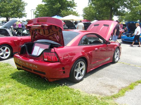 2007 Ford Mustang - A red Saleen Mustang is parked on grass and asphalt, with its trunk open to reveal framed documents.