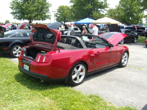 2007 Ford Mustang - Red 2007 Ford Mustang convertible at a car show with other vehicles.