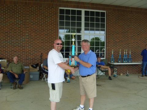 2007 Ford Mustang - Two men are holding a trophy at an outdoor event with other trophies displayed.