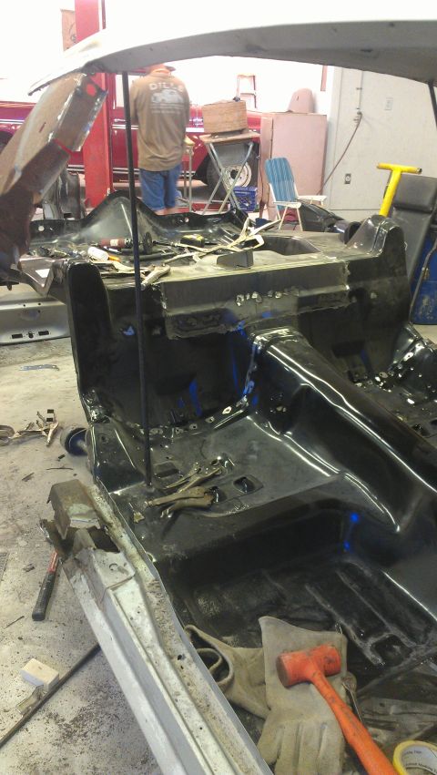 1980 Pontiac Trans Am - A car's interior structure is being worked on in a repair shop, with various tools scattered around.