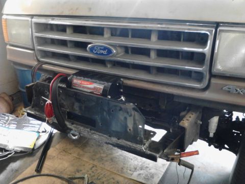 1989 Ford Bronco - Front view of a 1989 Ford Bronco, showing the grille and an installed winch with a red tow strap.
