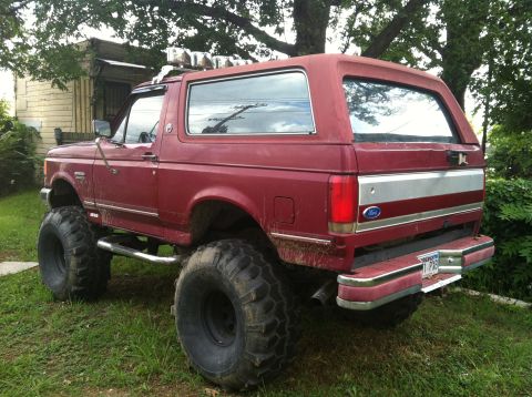 1991 Ford Bronco - This lifted Ford Bronco has oversized tires and a custom silver stripe across its rear.