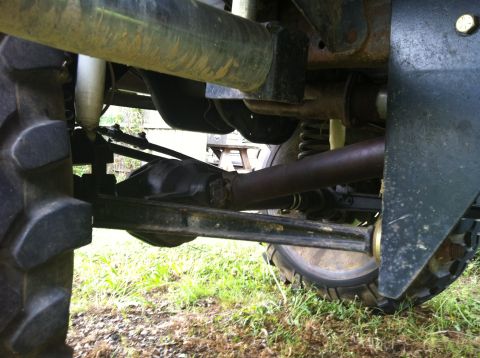 1991 Ford Bronco - Close-up view of a vehicle's undercarriage, focusing on the suspension and drive axle components.