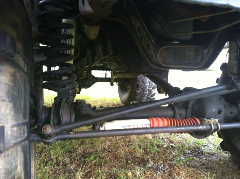 1991 Ford Bronco - The underside of a vehicle is visible, focusing on the suspension and steering mechanisms.