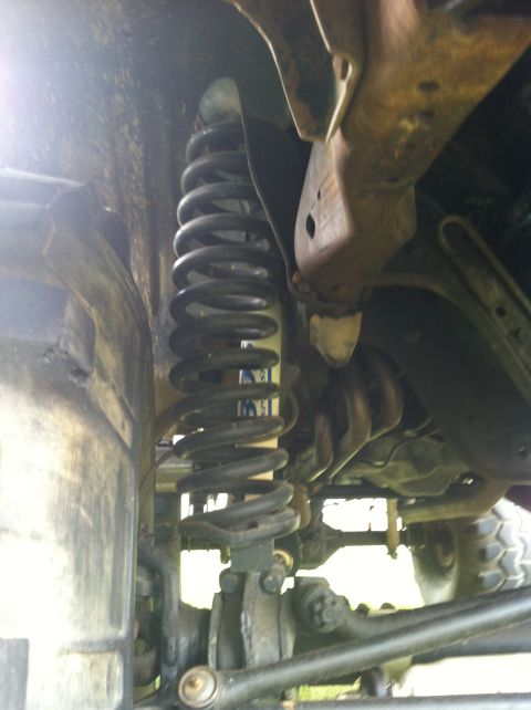 1991 Ford Bronco - Close-up view of the front suspension coil spring and associated linkage.