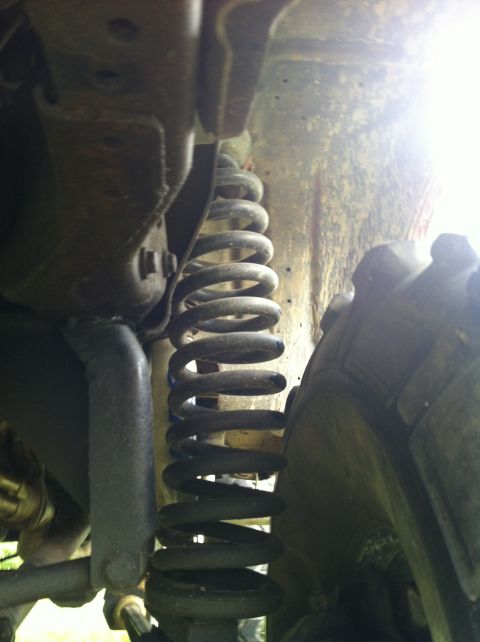 1991 Ford Bronco - Underside view of a vehicle's suspension system, showing a coil spring and tire.