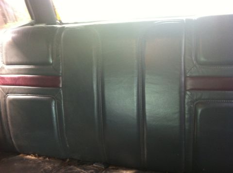 1991 Ford Bronco - Rear seat interior of a vehicle, showing dark upholstery with a burgundy accent stripe.