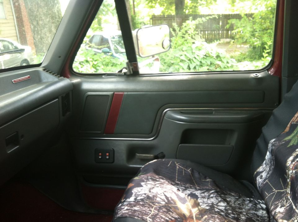Interior shot of a Ford Bronco, showing the door panel, seat cover, and view out the window