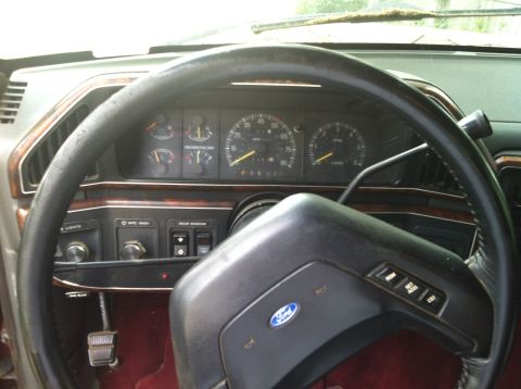 1991 Ford Bronco - Interior shot of a Ford vehicle, focusing on the dashboard and steering wheel area. The gauges show speed and RPM.