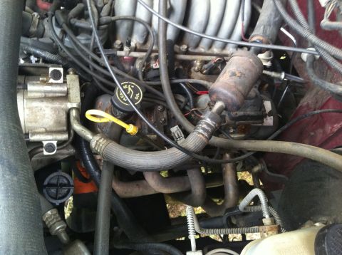 1991 Ford Bronco - The engine bay of a vehicle is shown with various components and wiring.