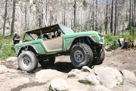 1991 Ford Bronco - Modified green Ford Bronco navigates a challenging rocky trail.