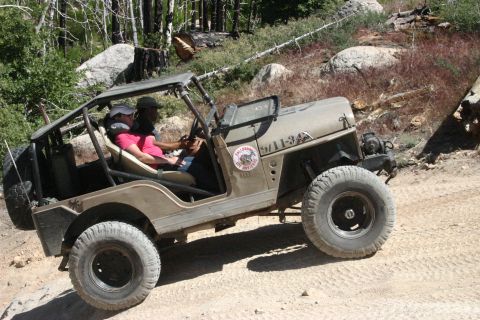 1991 Ford Bronco - A modified Jeep CJ-5 navigates a rocky, wooded off-road trail.