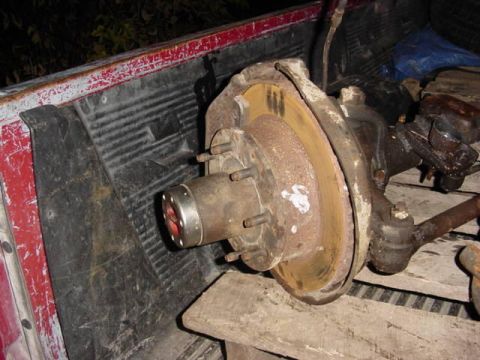 1992 Ford Bronco - Front axle assembly with brake rotor and tie rod end, likely for an older truck or SUV.