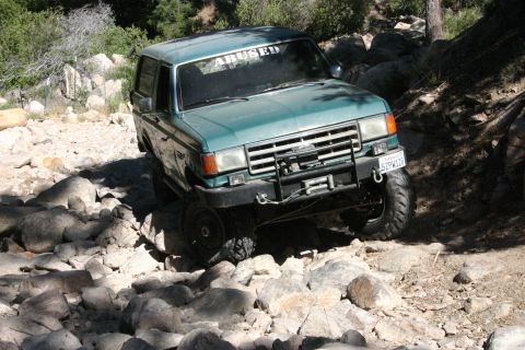 1991 Ford Bronco - This SUV is shown off-roading on a challenging rocky path.