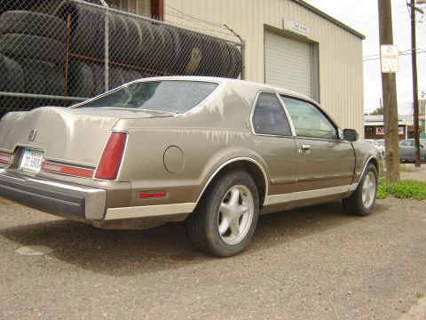 1987 Lincoln Mark VII - Rear view of a 1987 Lincoln Mark VII coupe parked on a gravel lot.