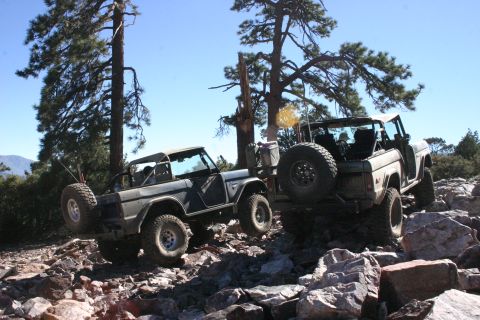 1991 Ford Bronco - Two Ford Broncos tackle a challenging rocky terrain, their off-road capabilities.