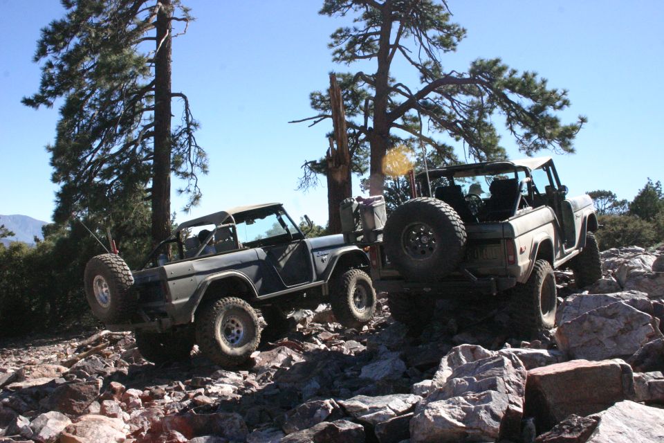 Two 1978 Ford Broncos navigating a rocky incline