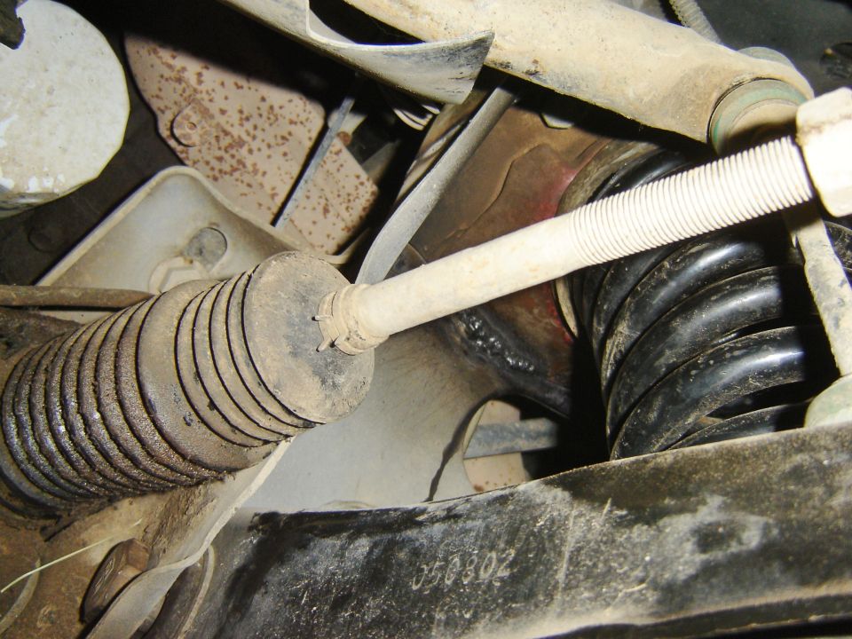 1987 Lincoln Mark VII suspension components, including a ribbed rubber boot and black coil spring