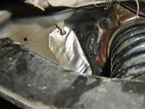 1987 Lincoln Mark VII - Undercarriage view of a vehicle's suspension components with a heat shield visible.