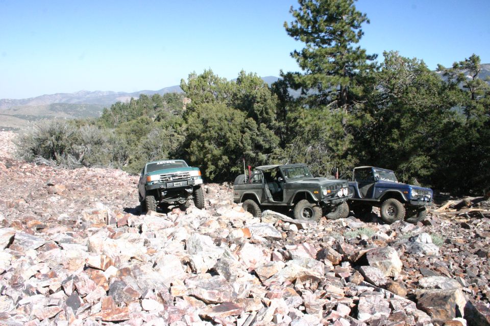 Dark green 1978 Ford Bronco and blue 1978 Ford Bronco on rocky trail