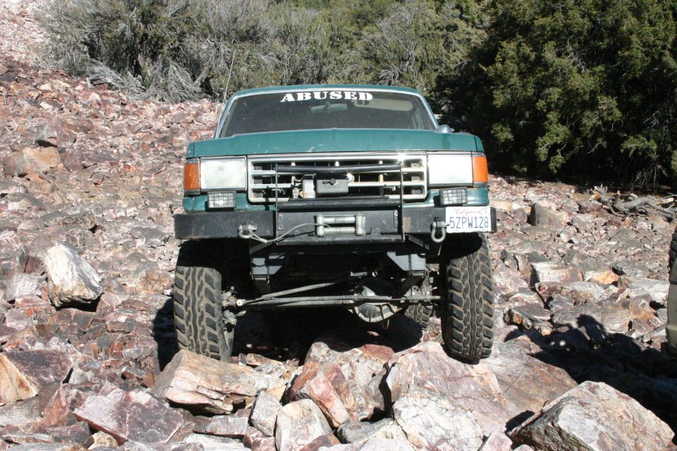 Green 1991 Ford Bronco front view with winch and "ABUSED" sticker