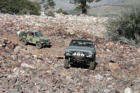 1991 Ford Bronco - Two trucks navigate a challenging rocky trail in a mountainous landscape.