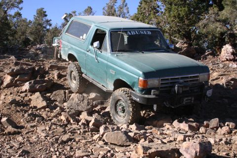 1991 Ford Bronco - This 1991 Ford Bronco is shown tackling a challenging off-road course with another vehicle visible in the background.
