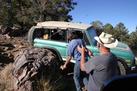 1991 Ford Bronco - Two men are helping a green Ford Bronco navigate a rocky, off-road path.