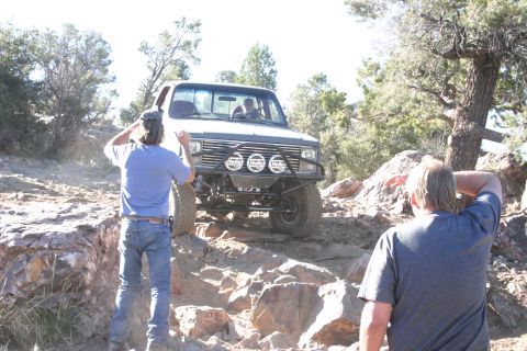 1991 Ford Bronco - This off-road truck navigates a rocky trail with two onlookers.