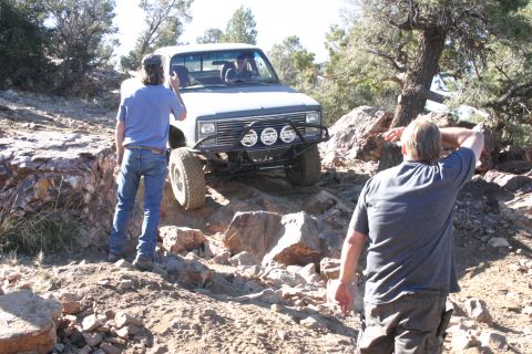 1991 Ford Bronco - Truck navigating a challenging rocky trail with onlookers.