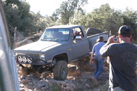 1991 Ford Bronco - A modified pickup truck is being photographed while traversing a difficult, rocky path.