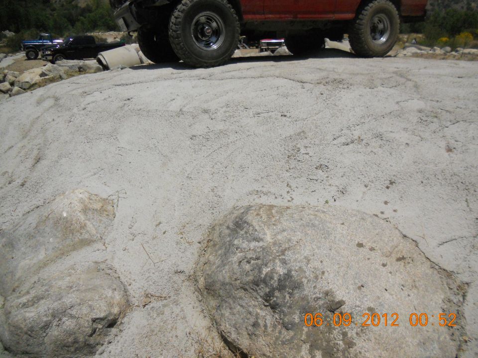 Red off-road vehicle and blue pickup truck on rocky ground