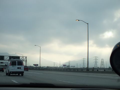 2003 Ford Crown Victoria - Highway driving scene with a white cargo van ahead and power towers along the median.