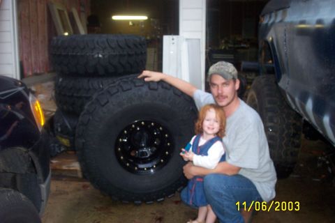 1979 Ford F-150 - A man and a child are pictured with several large tires, possibly for a truck or off-road vehicle.