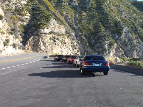 2003 Ford Crown Victoria - Lineup of sedans on a paved canyon turnout, lead Crown Victoria nearest camera with mountains behind