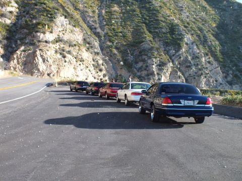 2003 Ford Crown Victoria - Sedans queued diagonally on mountain pullout, blue Crown Victoria foreground with California plate
