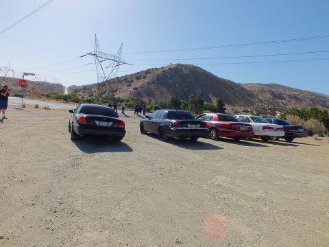 2003 Ford Crown Victoria - Sedan group parked at a desert pullout with power pylons, a stop sign and a brown hillside
