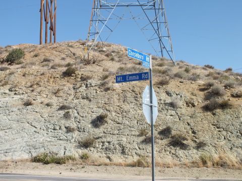 2003 Ford Crown Victoria - Intersection signs for Cheseboro Rd and Mt. Emma Rd stand below a steel power-line tower.