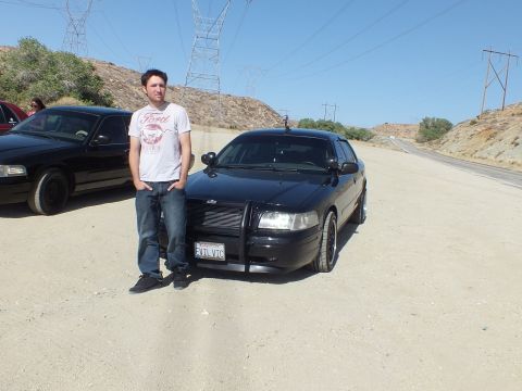 2003 Ford Crown Victoria - Owner posing next to his black Ford Crown Victoria fitted with a front push bar