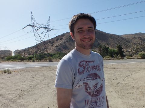 2003 Ford Crown Victoria - Man in a Ford Mustang t-shirt smiles roadside with transmission towers in the hills