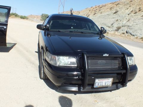 2003 Ford Crown Victoria - Front three-quarter of the EVIL VIC Crown Victoria parked on a dirt road